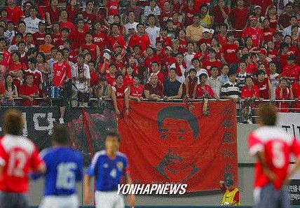 サッカーの国際戦で、“日本の総理大臣を殺害した韓国人テロリスト”の垂れ幕を掲げる韓国人サポーター