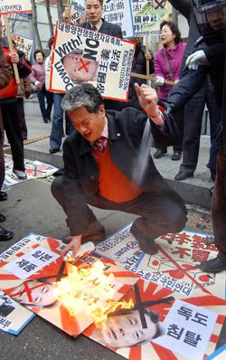 韓国の大人、日本の首相のポスターを燃やす